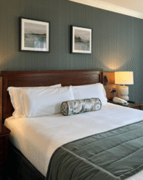 Elegant hotel room with king-size bed and serene decor.