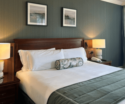 Cosy hotel room with a large bed and soft lighting, perfect for relaxation.