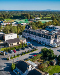 Aerial view of The Anner Hotel and surrounding greenery on a sunny day.