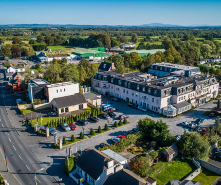 Aerial view of The Anner Hotel and surrounding greenery on a sunny day.