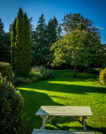 Scenic garden view with a picnic table at The Anner Hotel.