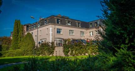 Charming hotel exterior with lush greenery, ideal for family getaways.