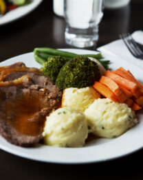 Delicious roast dinner with vegetables and mashed potatoes at a cosy hotel.