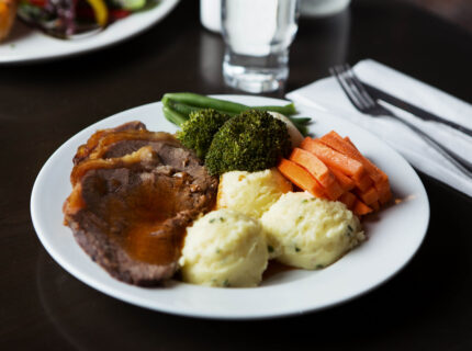Delicious roast dinner with vegetables and mashed potatoes at a cosy hotel.