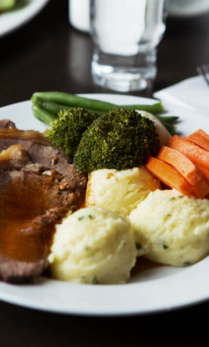 Delicious roast dinner with vegetables and mashed potatoes at a cosy hotel.