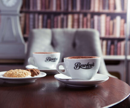 Cosy café setting with coffee and biscuits at The Anner Hotel, inviting library backdrop.