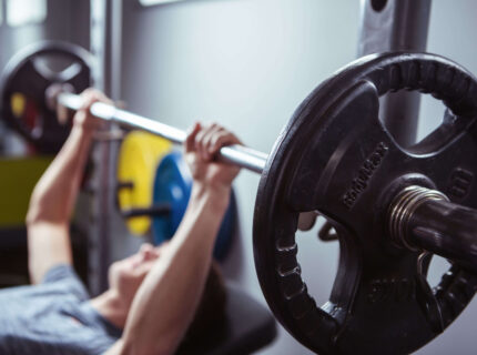 Family group exercising in hotel gym with vibrant equipment.