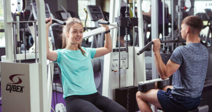 A couple enjoying a workout at The Anner Hotel gym, surrounded by modern fitness equipment.