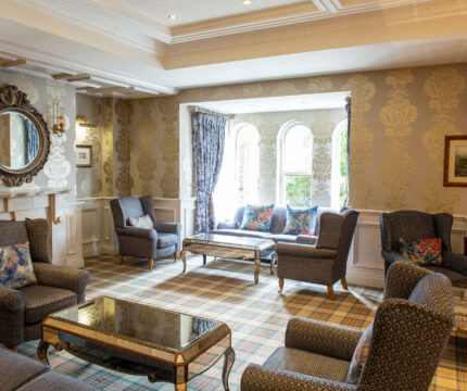 Elegant lounge with seating area, mirror, and window view in The Anner Hotel.
