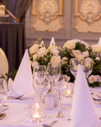 Elegant dining setup with white linens and flowers at The Anner Hotel's event space.