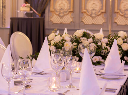 Elegant dining setup with white linens and flowers at The Anner Hotel's event space.