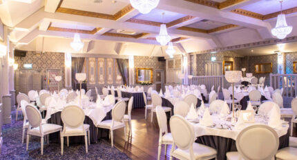 Elegant dining area with chandeliers, set for an event at The Anner Hotel.