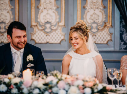 A joyful couple at a wedding reception in a beautifully decorated ballroom at The Anner Hotel.
