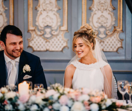 A joyful couple at a wedding reception in a beautifully decorated ballroom at The Anner Hotel.