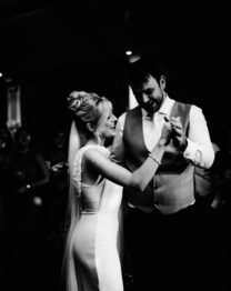 A joyous couple dancing under a chandelier at The Anner Hotel, surrounded by smiling guests.