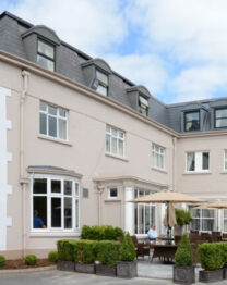 Family enjoys sunny terrace at elegant Anner Hotel, featuring classic architecture.