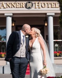 A happy couple shares a kiss outside The Anner Hotel entrance.