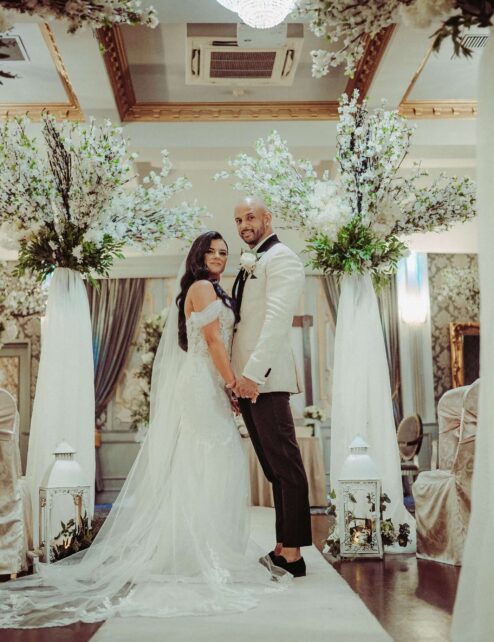 A couple stands joyfully in a beautifully decorated wedding venue at The Anner Hotel.