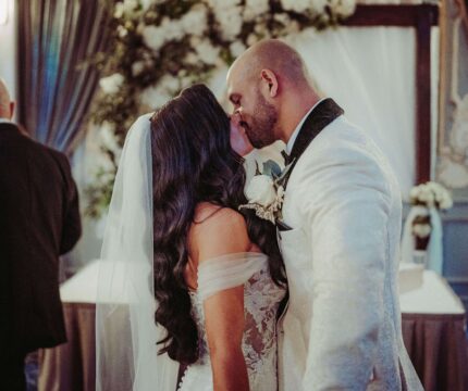 A couple shares a romantic kiss at an elegant wedding reception in The Anner Hotel.