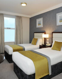 Elegant twin room at The Anner Hotel with cosy beds and warm lighting.