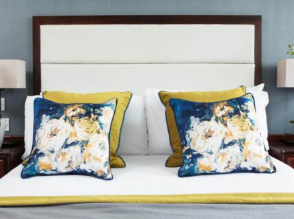 Elegant hotel room with floral pillows and fresh orchids enhancing a welcoming atmosphere.