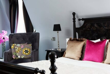 Elegant hotel room with plush pillows and bright pink accents.