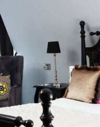 Luxurious hotel room with a plush bed, vibrant cushions, and elegant decor.
