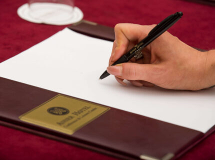 Hand writing on notepad at conference in cosy hotel setting.