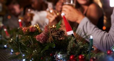 Festive family enjoying drinks at a decorated Christmas table.