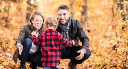 Family enjoying autumn stroll in vibrant forest.