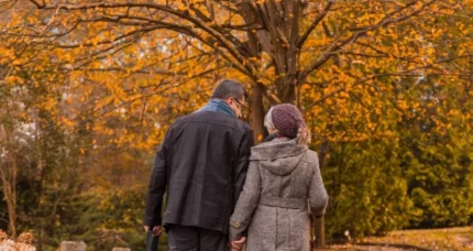 Couple walking along a scenic path lined with autumn trees at The Anner Hotel.
