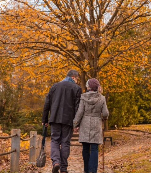 Couple walking along a scenic path lined with autumn trees at The Anner Hotel.